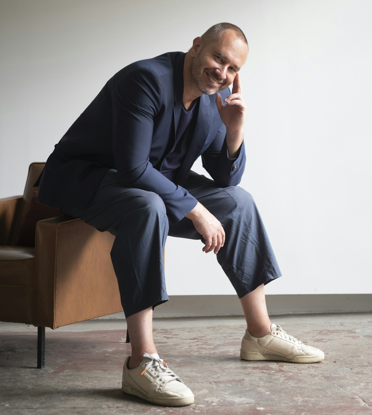 Alain Gilles x BuzziSpace Portrait of designer Alain Gilles sitting on a chair