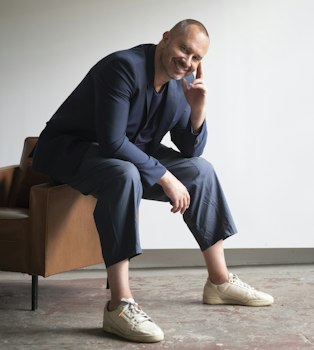 Alain Gilles x BuzziSpace Portrait of designer Alain Gilles sitting on a chair